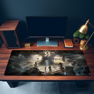 Op de afbeelding: Een rechthoekige bureaumat met een donkere, sfeervolle fantasy-illustratie met meerdere figuren die op rotsachtig terrein staan onder een gloeiend gouden symbool. Het kunstwerk toont een dramatisch landschap met wervelende wolken en schaduwen.