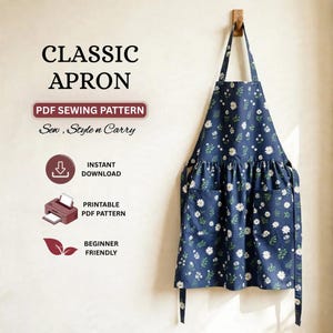 May include: A navy blue apron featuring a white daisy and green leaf pattern, with two front pockets and a neck strap. Text includes CLASSIC APRON, PDF SEWING PATTERN, Sew, Style n Carry, INSTANT DOWNLOAD, PRINTABLE PDF PATTERN, and BEGINNER FRIENDLY.