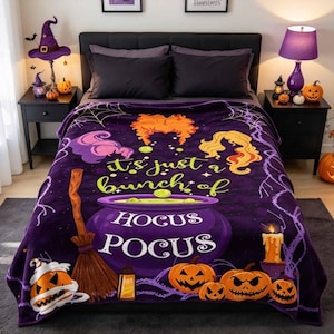 May include: A purple fleece blanket featuring Hocus Pocus graphics including a cauldron, broomstick, jack-o'-lanterns, and the text "it's just a bunch of HOCUS POCUS". The design includes stylized hair illustrations, spiderwebs, and a candle.