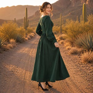 Puede incluir: Un vestido largo de color verde oscuro con mangas largas, que presenta un corpi&ntilde;o ajustado y una falda amplia y fluida. El vestido tiene un cuello alto y mangas largas con pu&ntilde;os, combinado con zapatos de tac&oacute;n alto de color negro.