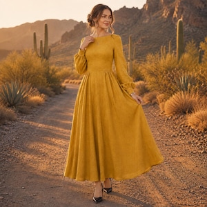Puede incluir: Un vestido largo de color amarillo mostaza con mangas largas, cuerpo ajustado, cuello alto y una falda amplia y fluida. El vestido presenta mangas largas con pu&ntilde;os fruncidos y un acabado de tela s&oacute;lida y texturizada, creando una silueta sencilla.