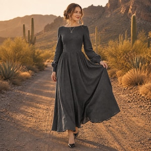 Puede incluir: Un vestido largo de color gris carb&oacute;n con mangas largas, cuerpo ajustado, cuello redondo y una falda amplia y fluida. La prenda presenta un dise&ntilde;o sencillo y liso con mangas largas que se recogen en las mu&ntilde;ecas y una cintura entallada.