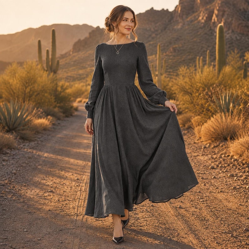 Puede incluir: Un vestido largo de color gris carb&oacute;n con mangas largas, cuerpo ajustado, cuello redondo y una falda amplia y fluida. La prenda presenta un dise&ntilde;o sencillo y liso con mangas largas que se recogen en las mu&ntilde;ecas y una cintura entallada.