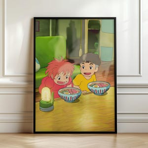 Può includere: Una stampa artistica da parete incorniciata che raffigura una scena animata di due bambini con capelli rossi e castani seduti a un tavolo con ciotole di ramen. Una piccola lanterna verde è sul tavolo e una sedia verde brillante è sullo sfondo.