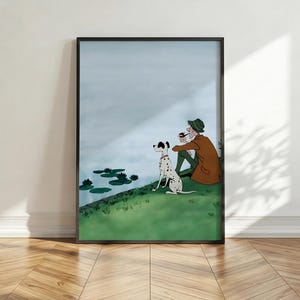 Könnte beinhalten: Eine gerahmte Illustration, die eine Person mit braunem Mantel und grünem Hut zeigt, die zusammen mit einem Dalmatiner auf einer grasbewachsenen Uferböschung sitzt. Beide blicken auf ein ruhiges Gewässer mit dunkelgrünen Seerosenblättern.