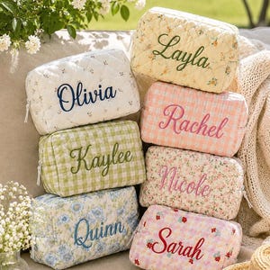 Puede incluir: Una colección de seis neceseres rectangulares acolchados con varios estampados florales y de cuadros vichy en colores pastel. Cada neceser está personalizado con nombres bordados: Layla, Olivia, Rachel, Kaylee, Nicole y Sarah.
