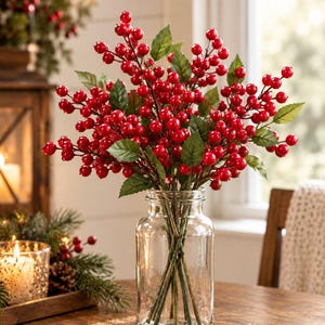 Peut inclure: Un bocal en verre transparent contenant un arrangement dense de tiges de baies rouges artificielles avec des feuilles vertes. Les tiges sont fines et brunes, soutenant des grappes de petites baies rouges rondes et brillantes.