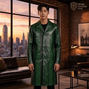 Può includere: Un lungo cappotto in pelle verde smeraldo con una trama testurizzata a pelle di serpente, dotato di revers dentellato, quattro bottoni frontali e due tasche laterali. Nell'angolo in alto a destra è presente il testo PRIME LEATHER CO22 con logo.