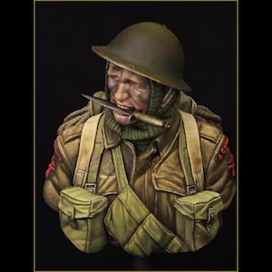 May include: A detailed military bust figurine depicting a soldier wearing a dark olive drab helmet, a green knit balaclava, and a tan jacket with two front pockets. The soldier has a silver combat knife held firmly between their teeth.