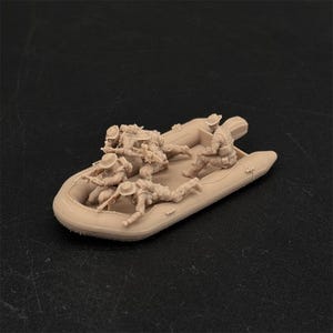 May include: A beige scale model of an inflatable boat carrying four figures in tactical gear. The figures are positioned in various poses, with some holding rifles. The boat features a rear motor mount and molded details on the floor and sides.