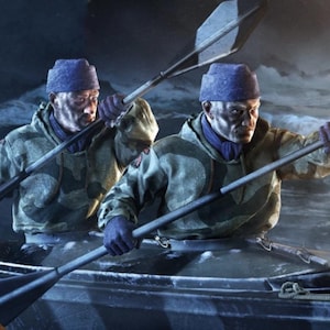 Puede incluir: Dos personas en un kayak oscuro con chaquetas de camuflaje con capucha, gorros de punto azul y guantes azules. Cada persona sostiene un remo largo, navegando por aguas oscuras y heladas. La escena captura un momento de remo con equipo visible.
