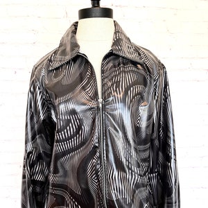 May include: A black and white patterned jacket with a zipper closure. The jacket has a shiny, almost metallic finish.