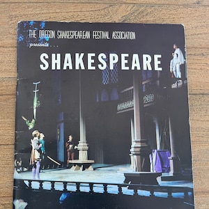 May include: A black and white program for the Oregon Shakespearean Festival Association's 25th season in 1965. The program features a photo of a stage set with actors in costume. The text "SHAKESPEARE" is printed in large white letters at the top of the program.