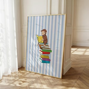 May include: A framed wall art print featuring a brown monkey sitting atop a vertical stack of colorful books. The monkey holds a yellow book titled Curious George. The background consists of vertical light blue and white stripes on the print.