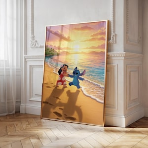 Op de afbeelding: Een ingelijste muurkunstprint met Lilo en Stitch die hand in hand over een zandstrand lopen bij zonsondergang. De scène toont een gouden lucht, kalme oceaangolven en de twee figuren die lange schaduwen werpen op het zand bij de waterlijn.