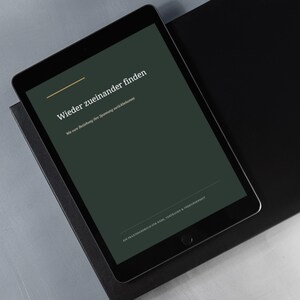 Könnte beinhalten: Ein schwarzes Tablet mit einem dunkelgrünen Bildschirm, auf dem der weiße Text Wieder zueinander finden, Wie eure Beziehung ihre Spannung zurückbekommt und EIN PRAXISHANDBUCH FÜR NÄHE, VERTRAUEN & VERBUNDENHEIT sowie eine dünne goldene Linie zu sehen ist.