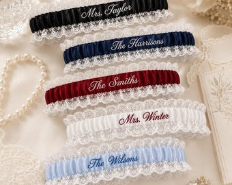 Personalisiertes, besticktes Spitzenstrumpfband für die Hochzeit: Individuell gestaltetes Erinnerungsstück mit dem Nachnamen der Braut, elastisches Accessoire in Einheitsgröße, erhältlich in fünf eleganten Farben.