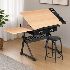 May include: A drafting table with a light wood-grain surface, an adjustable tilted top, and a side extension. The black metal frame includes two drawers, a perforated storage shelf, and a black stool with a round seat and four legs.