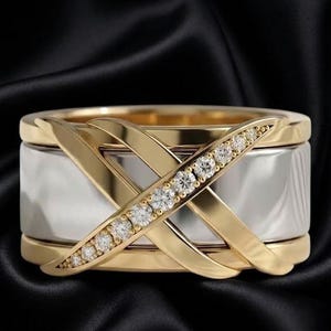 Peut inclure: Une bague large composée d'une section centrale argentée polie encadrée par deux bandes dorées. Une superposition dorée en forme de X traverse le centre, avec une branche du X ornée d'une rangée de petites pierres précieuses rondes et claires.