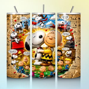 Op de afbeelding: Een cilindervormige beker met een collage van Peanuts-stripverhalen en kleurrijke illustraties van Charlie Brown en Snoopy. Het ontwerp bevat diverse scènes, tekstballonnen, rode hartjes en een rietje dat uit het deksel steekt.