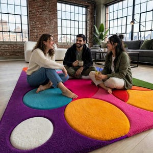May include: A rectangular area rug featuring a vibrant, multi-colored geometric pattern with large, plush circular and oval shapes in shades of purple, magenta, bright orange, teal, and white, set against a deep purple background.