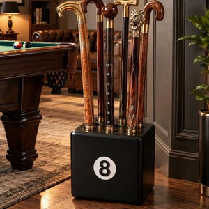May include: A black cube-shaped stand featuring a white number 8 graphic, holding five walking sticks. The sticks include various wooden shafts with ornate gold, brass, and silver-toned handles, including one with a detailed lion head design.