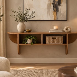 May include: A wall-mounted wooden console shelf featuring a long, flat top surface and a lower storage section divided into two open compartments. The shelf has curved side supports and a natural wood grain finish, providing a sturdy display area.
