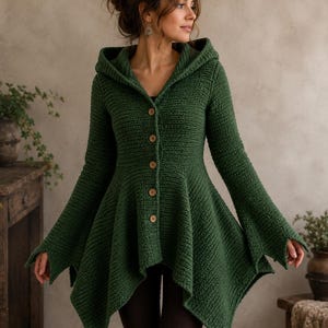 May include: A forest green hooded cardigan featuring a textured crochet knit pattern, a flared hemline, and a front button closure with five light brown wooden buttons. The garment has long, wide sleeves and a fitted bodice that transitions into a flared skirt.