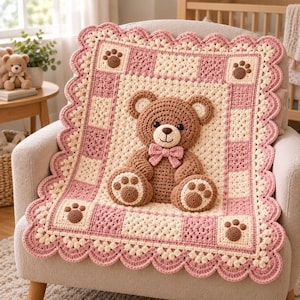 Può includere: Una coperta quadrata all'uncinetto con un orsacchiotto marrone tridimensionale al centro con un papillon rosa. La coperta presenta un motivo a scacchi color crema e rosa antico, accentuato da impronte di zampe marroni e un bordo smerlato.