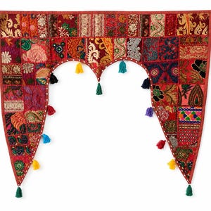 Könnte beinhalten: Ein dekorativer Türbehang aus einem Patchwork verschiedener roter Stoffe mit aufwendigen Stickereien, metallischen Garnakzenten und Blumenmustern. Die bogenförmige Unterkante ist mit mehreren bunten, hängenden Stoffquasten verziert.