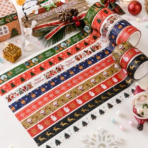 May include: A collection of decorative adhesive washi tapes featuring various Christmas-themed patterns including Santa Claus, reindeer, snowflakes, pine trees, and gift boxes, with some rolls displaying the text Merry Christmas in red or green.