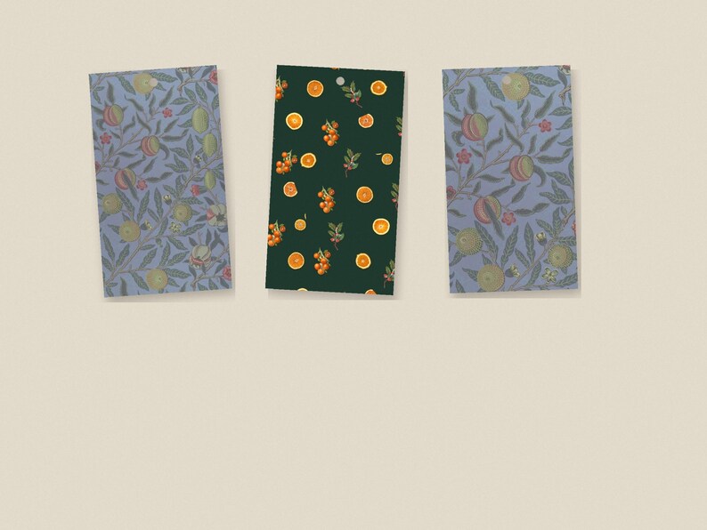 May include: Three rectangular gift tags with rounded top corners. The two outer tags feature a blue background with a repeating pattern of green leaves and round fruit. The center tag has a dark green background with orange fruit slices.