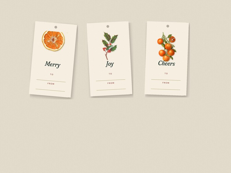 May include: Three rectangular cream-colored gift tags with a hole at the top. The first tag features a sliced orange and the word Merry. The second tag shows holly berries and the word Joy. The third tag displays oranges and the word Cheers.
