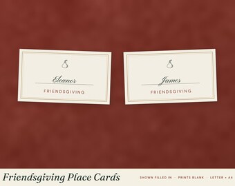 May include: Two rectangular off-white place cards with a thin brown border. Each card features a small pear illustration, a name written in script, and the word FRIENDSGIVING in brown capital letters. The names are Eleanor and James.