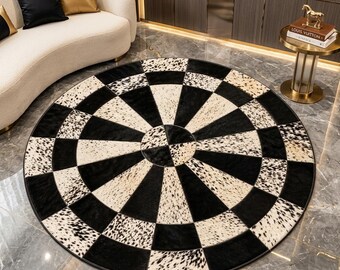 May include: A circular area rug featuring a geometric pattern of alternating black solid panels and white panels with black speckled animal print. The rug is constructed from pieced segments arranged in a radial design with a central circular focal point.