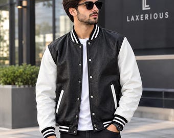 May include: A varsity jacket featuring a black textured body and white sleeves. The jacket has a snap-button front closure, white and black striped ribbed cuffs, a ribbed collar, and two side pockets with white trim, worn over a plain white t-shirt.