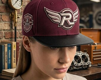 May include: A maroon baseball cap with a black brim featuring a large embroidered white and maroon winged letter R logo on the front and a shield-shaped patch on the side with the text Premium Race Works Est 2024 and a piston graphic.