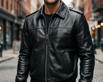 May include: A black leather jacket featuring a classic collar, a full-length metal front zipper, and shoulder epaulets. The garment includes ribbed cuffs and a ribbed hem, with two slanted side pockets and a smooth, polished finish throughout.