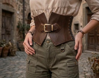 May include: A wide brown corset belt featuring a central buckle closure and side lace-up details, worn over a beige long-sleeve top and olive green cargo shorts with multiple pockets and a button fly, creating a structured layered appearance.
