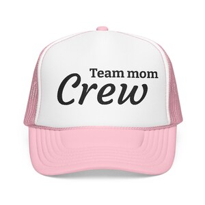 Op de afbeelding: Een lichtroze en witte truckerpet met een mesh achterkant en een stevig voorpaneel. Op de voorkant staat de zwarte tekst Team mom Crew in een combinatie van een standaard schreefloos lettertype en een groter, vet cursief lettertype.