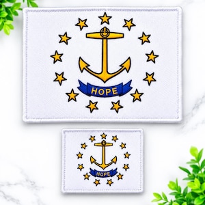 May include: Two rectangular embroidered patches featuring the Rhode Island state flag design. Each patch has a white background with a central gold anchor surrounded by thirteen gold stars and a blue ribbon banner with the word HOPE in gold text.