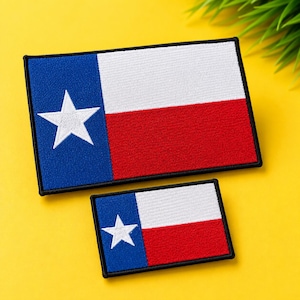 May include: Two rectangular embroidered patches featuring the Texas state flag design. Each patch has a vertical blue stripe on the left with a single white star, followed by horizontal white and red stripes on the right, all bordered in black.