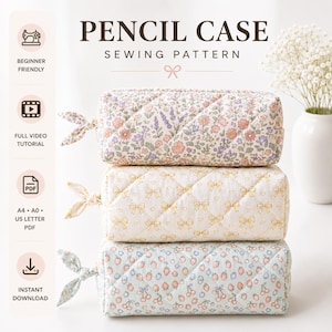 Op de afbeelding: Een stapel van drie doorgestikte etuis met stoffen striksluitingen. Het bovenste etui heeft een bloemenprint, het middelste een geel strikjespatroon en het onderste een aardbeienprint. De tekst luidt PENCIL CASE SEWING PATTERN.