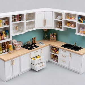 Può includere: Un set da cucina in miniatura a forma di L con armadietti bianchi e maniglie dorate, un piano di lavoro in legno chiaro, un piano cottura nero e un doppio lavello nero. Gli scaffali sono pieni di contenitori e accessori da cucina.
