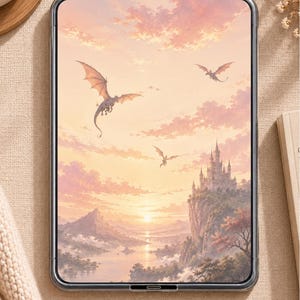 Op de afbeelding: Een rechthoekige tablet met een donker frame toont een digitale illustratie van een fantasielandschap bij zonsondergang. De scène bevat een kasteel op een klif, een riviervallei en drie draken die door een zachte roze en oranje lucht vliegen.