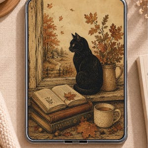 May include: A digital tablet displaying an illustration of a black cat sitting on a windowsill next to a stack of books, a mug, and a vase of autumn leaves. The scene shows a rural landscape through the window with orange trees and a small house.