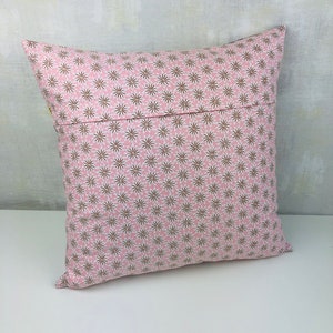 Puede incluir: Una almohada rosa con un patr&oacute;n de estrellas marrones y blancas. La almohada est&aacute; hecha de una tela suave y c&oacute;moda y tiene una cremallera.