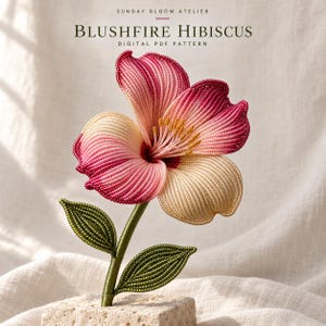 May include: A beaded hibiscus flower sculpture titled Blushfire Hibiscus Digital PDF Pattern. The flower features petals in gradient shades of cream, soft pink, and deep magenta, with yellow stamens, green beaded leaves, and a green stem on a stone base.