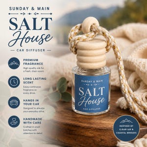 May include: A clear glass car diffuser bottle with a wooden cap and a thick braided rope. The blue label features the text "SUNDAY & MAIN SALT HOUSE CAR DIFFUSER". The product is presented with text detailing features like premium fragrance and long-lasting scent.