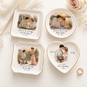 May include: Four white ceramic trinket dishes with gold-painted rims, each featuring custom illustrations of a couple and personalised text. The designs depict romantic scenes, including a proposal and wedding, with names and dates printed on each.
